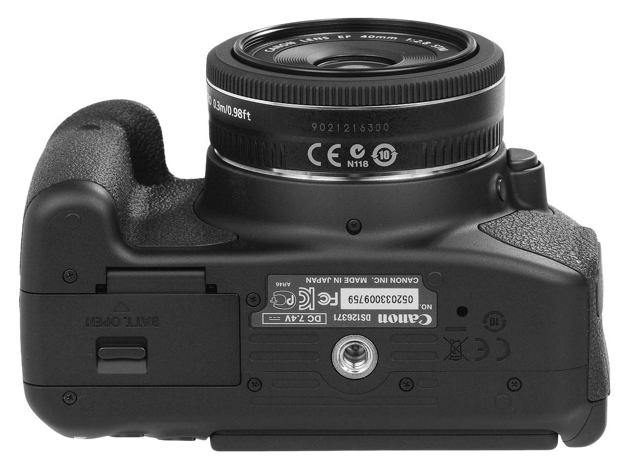 Bottom view of a Canon DSLR camera showing the battery compartment, tripod mount, and lens release button